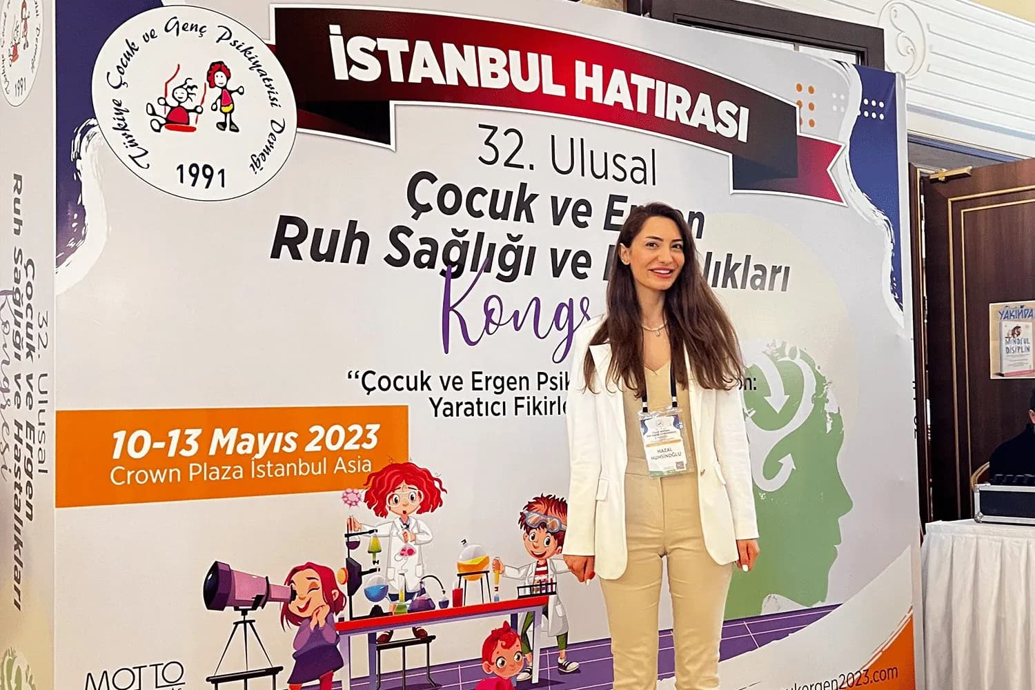 Uzm. Dr. Hazal Tonya, 32. Ulusal Çocuk ve Ergen Ruh Sağlığı ve Hastalıkları Kongresi panosunun önünde